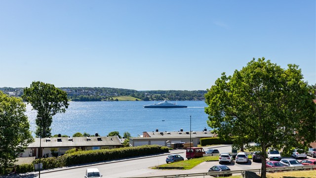 Utsikt fra verandaen til Værlebukta med det frodige Festelandet i bakgrunnen - fremhevet med zoom.