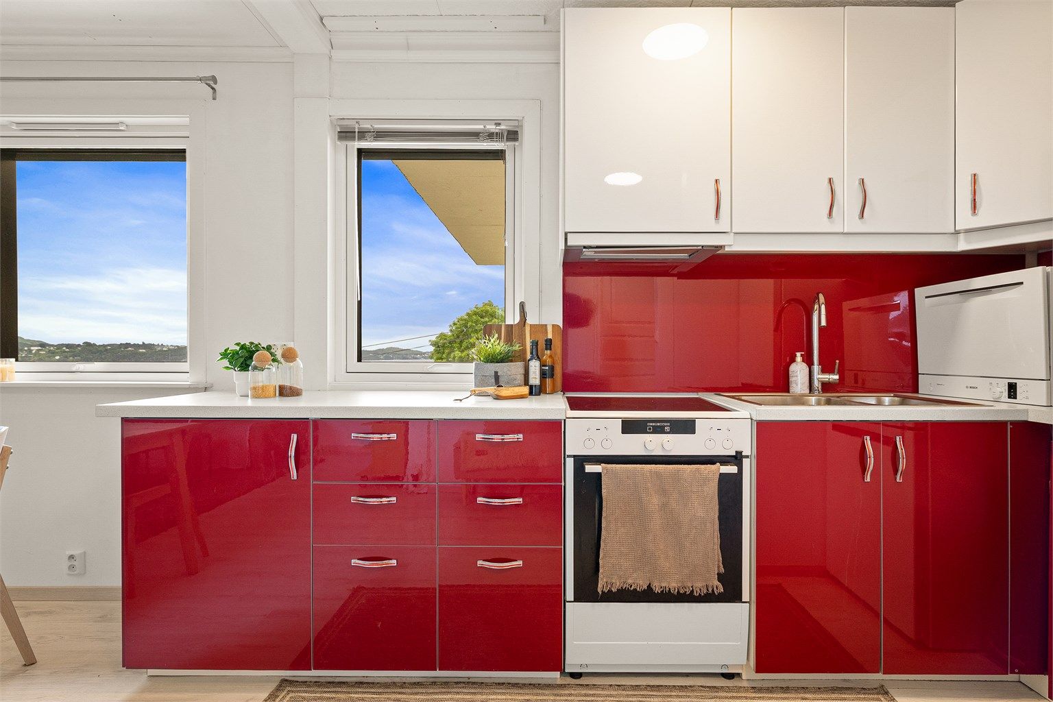 Stilrent IKEA-kjøkken fra 2018 med glatte fronter og benkeplate av laminat. Utstyrt med frittstående komfyr, kjøleskap og oppvaskmaskin.