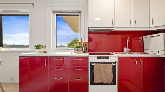 Stilrent IKEA-kjøkken fra 2018 med glatte fronter og benkeplate av laminat. Utstyrt med frittstående komfyr, kjøleskap og oppvaskmaskin.