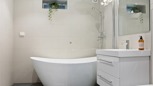 Komplett baderom med flislagte overflater og downlights i himlingen.