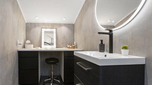 Baderommet er innredet med praktisk sminkebord og downlights i himlingen.