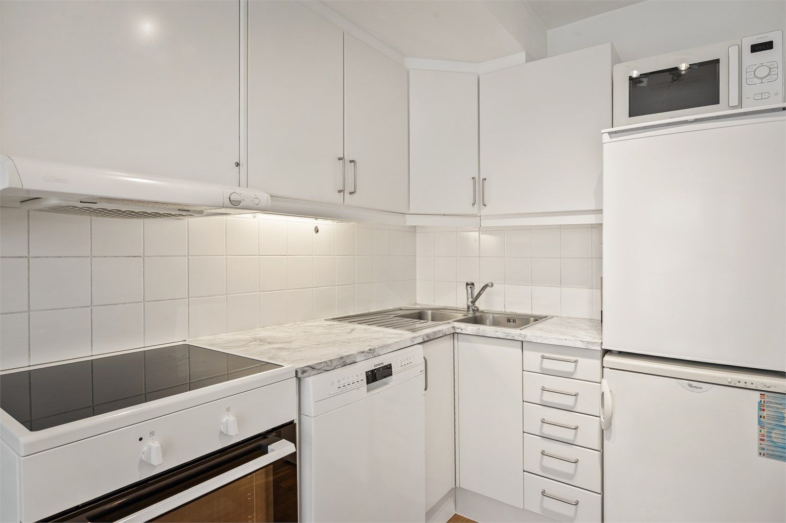 Kjøkken med innredning med glatte fronter. Benkeplate med laminert overflate og nedfelt kjøkkenvask.