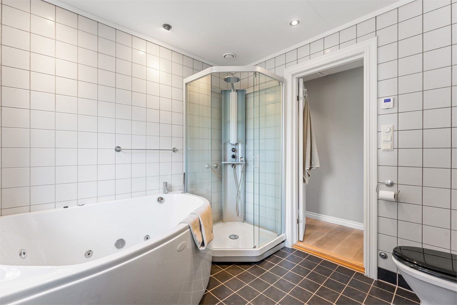Badet har flislagt gulv med varme og mekanisk avtrekksventil i himling.