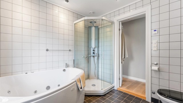 Badet har flislagt gulv med varme og mekanisk avtrekksventil i himling.