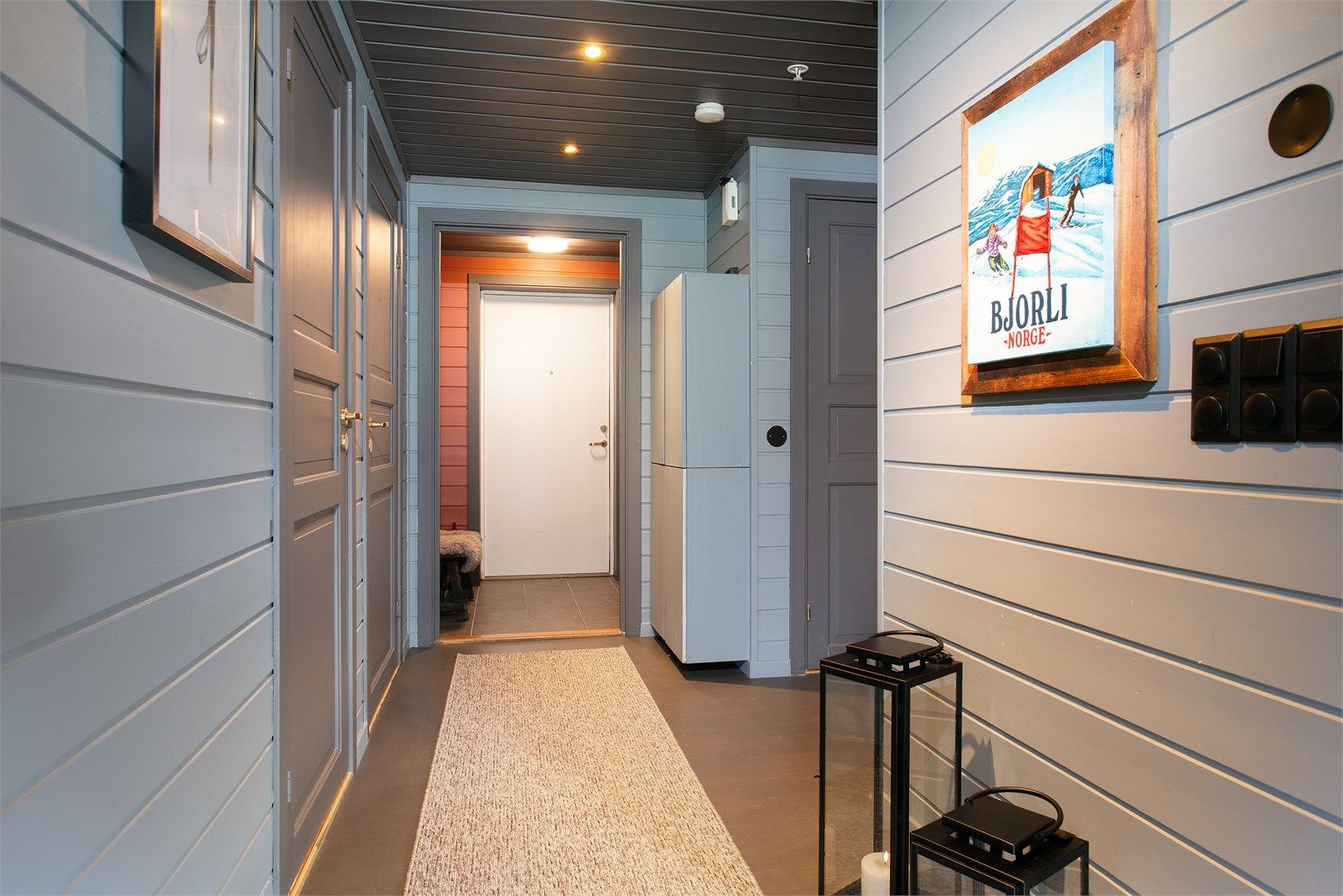 Gangen er innredet med malt trepanel og downlights i himlingen.