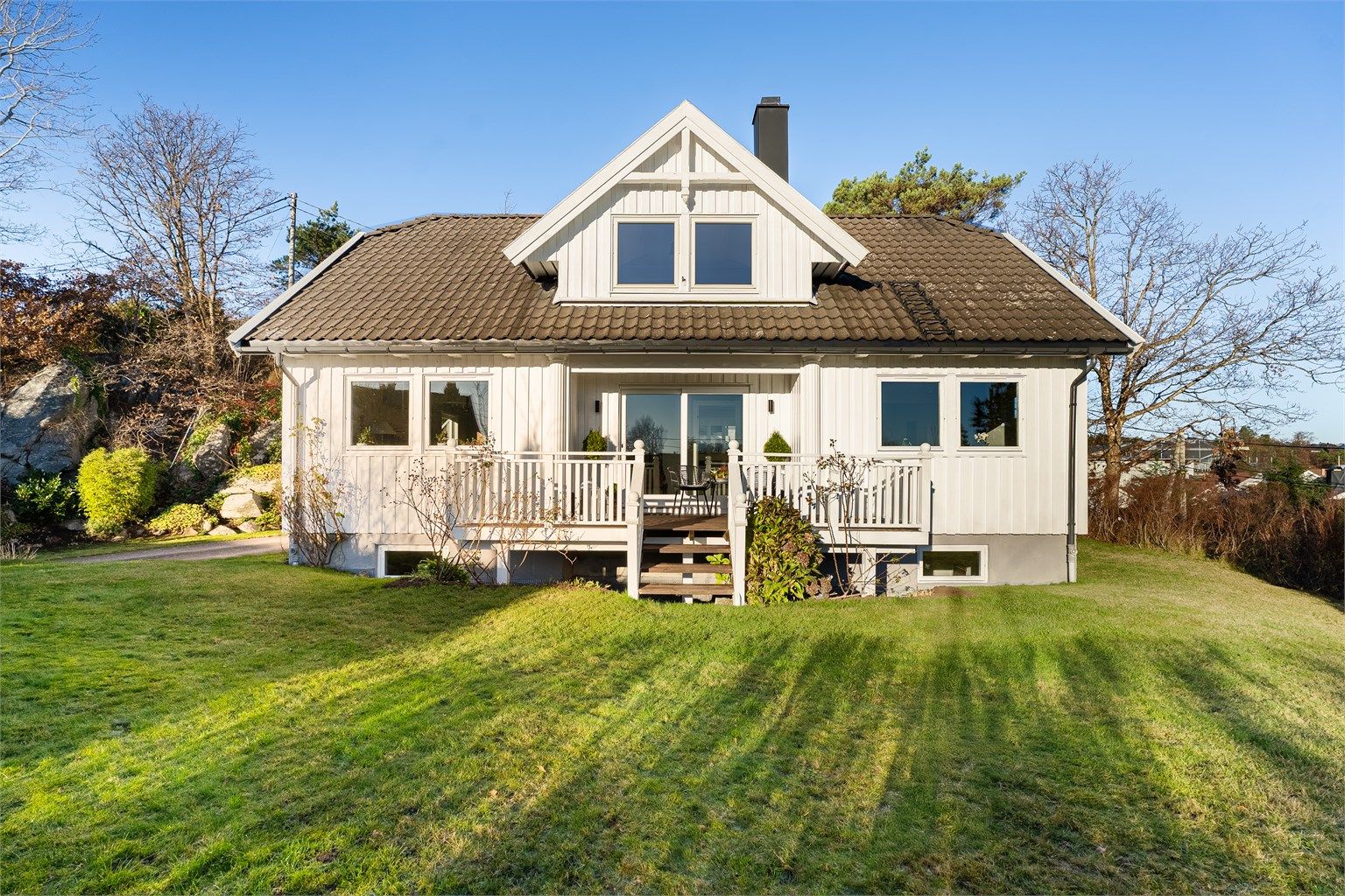 Plenlagt hage og terrasse på fremsiden.