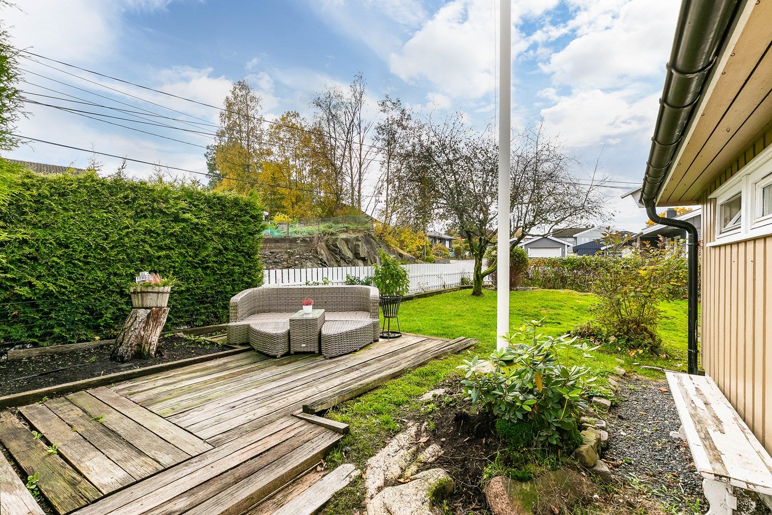 Tomten er eiet, på 874 kvm. og opparbeidet med hage rundt tre sider av boligen.