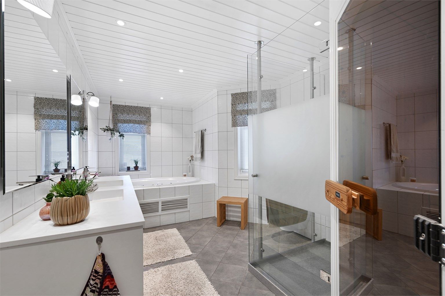 Et romslig og komplett bad med både dusj, badekar og badstue.