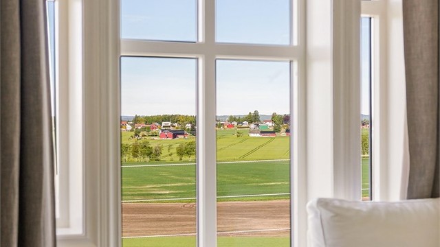 Fra loftstuen er det utsikt over nærområdet og de omkringliggende jordene.