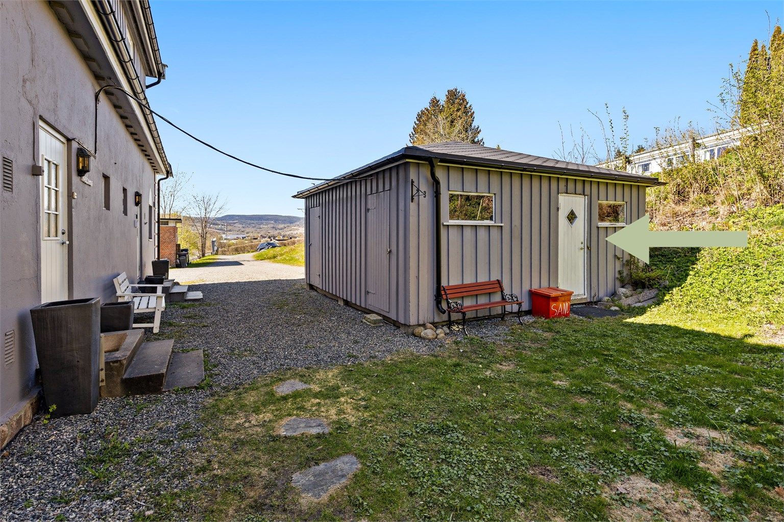 Sameiet består av fire seksjoner og har felles, gruslagt gårdsplass. Inngang til boden. 