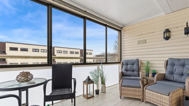 Den romslige, innglassede balkongen på 10 m² utvider stuen og har sol fra ettermiddag til kveld.