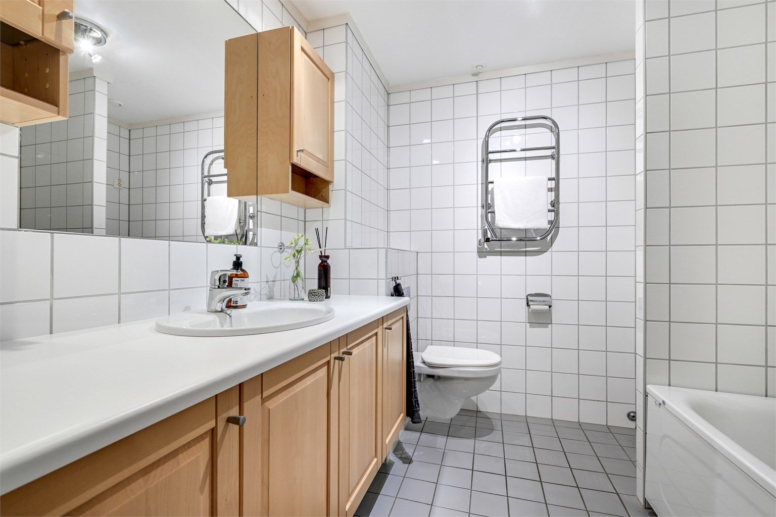 Badet tilhørende hovedsoverom er Innredet med dusj/badekar, servant og vegghengt klosett. 