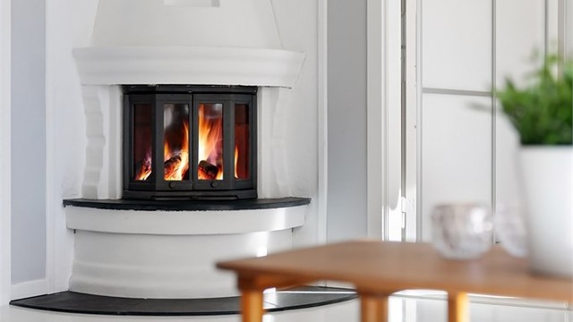 Peisovn med glassdør, installert på en skorstein fra byggeåret.
