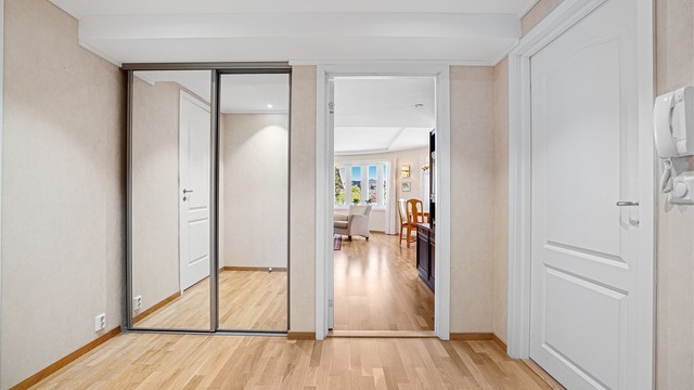 Gang/entré med skyvedørsgarderobe samt inngang til boligens andre soverom.