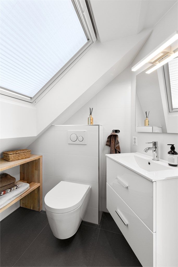 Badet har flislagt gulv med gulvvarme, flislagte vegger og innfelt spotbelysning