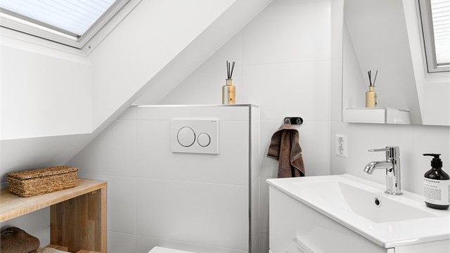 Badet har flislagt gulv med gulvvarme, flislagte vegger og innfelt spotbelysning