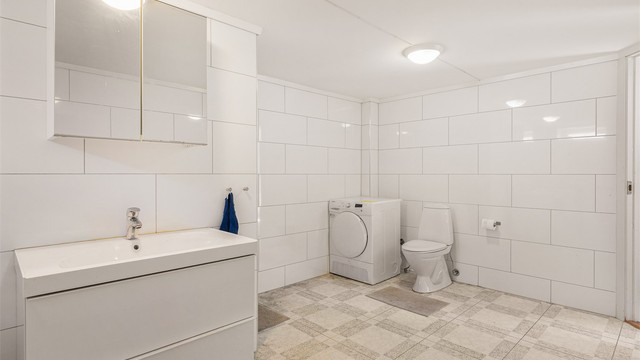 Badet er utstyrt med servant i seksjon med speilskap over, vaskeromsinnredning med utslagsvask og opplegg for vaskemaskin, dusjnisje og mekanisk avtrekksvifte på vegg (ikke godkjent til varig opphold).
