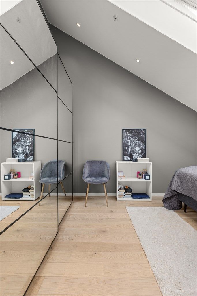 Soverommet fremstår som både praktisk og innbydende, med enstavs parkettgulv, stor skyvedørsgarderobe og integrert belysning i form av downlights.