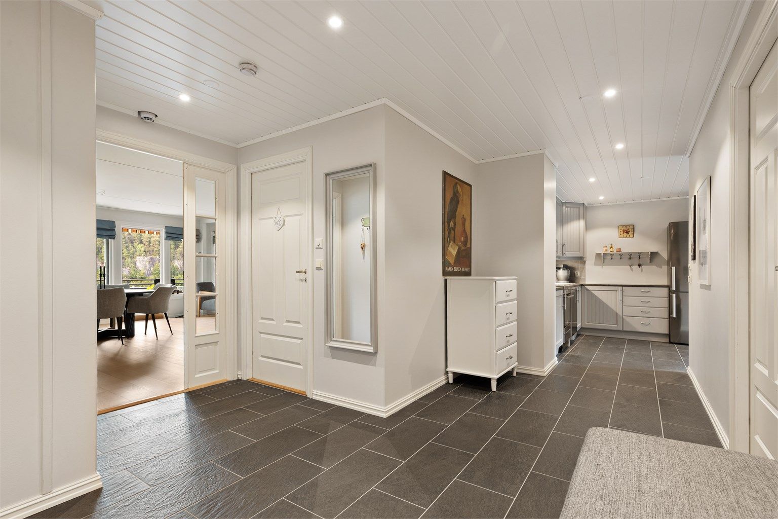 Stor entré med god plass til oppbevaring, fliser på gulv med gulvvarme og downlights i taket. Fra entréen er det videre adkomst inn i til kjøkkenet, stuen, begge soverom, samt bad og wc.