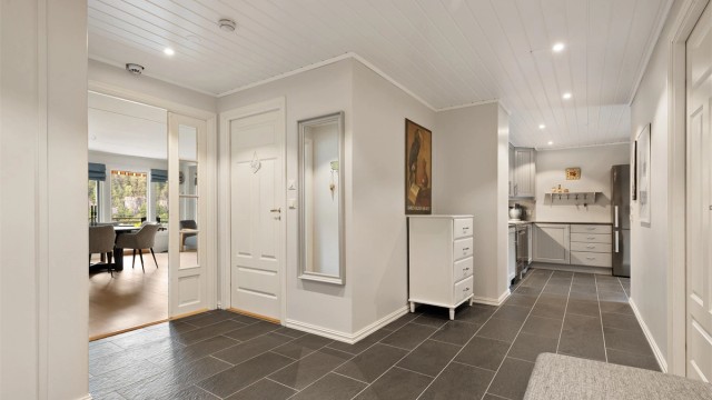 Stor entré med god plass til oppbevaring, fliser på gulv med gulvvarme og downlights i taket. Fra entréen er det videre adkomst inn i til kjøkkenet, stuen, begge soverom, samt bad og wc.