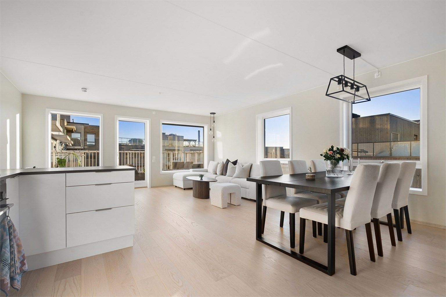 En stilren hjørneleilighet med store vindusflater og to balkonger. Alle vinduene i stuen har montert utvendige elektriske persienner.