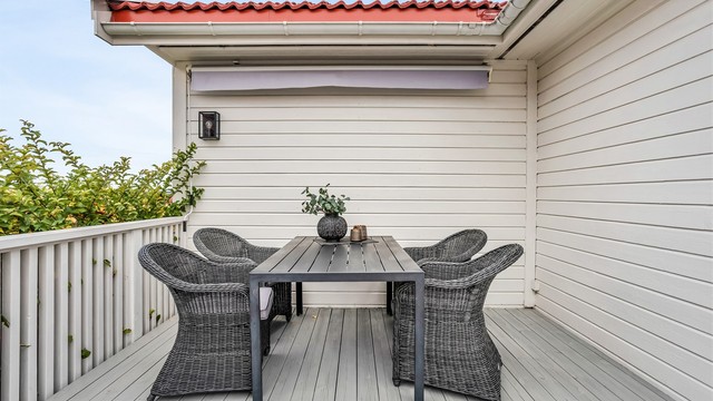 Terrasse ved inngangspartiet med plass til bord og stoler.