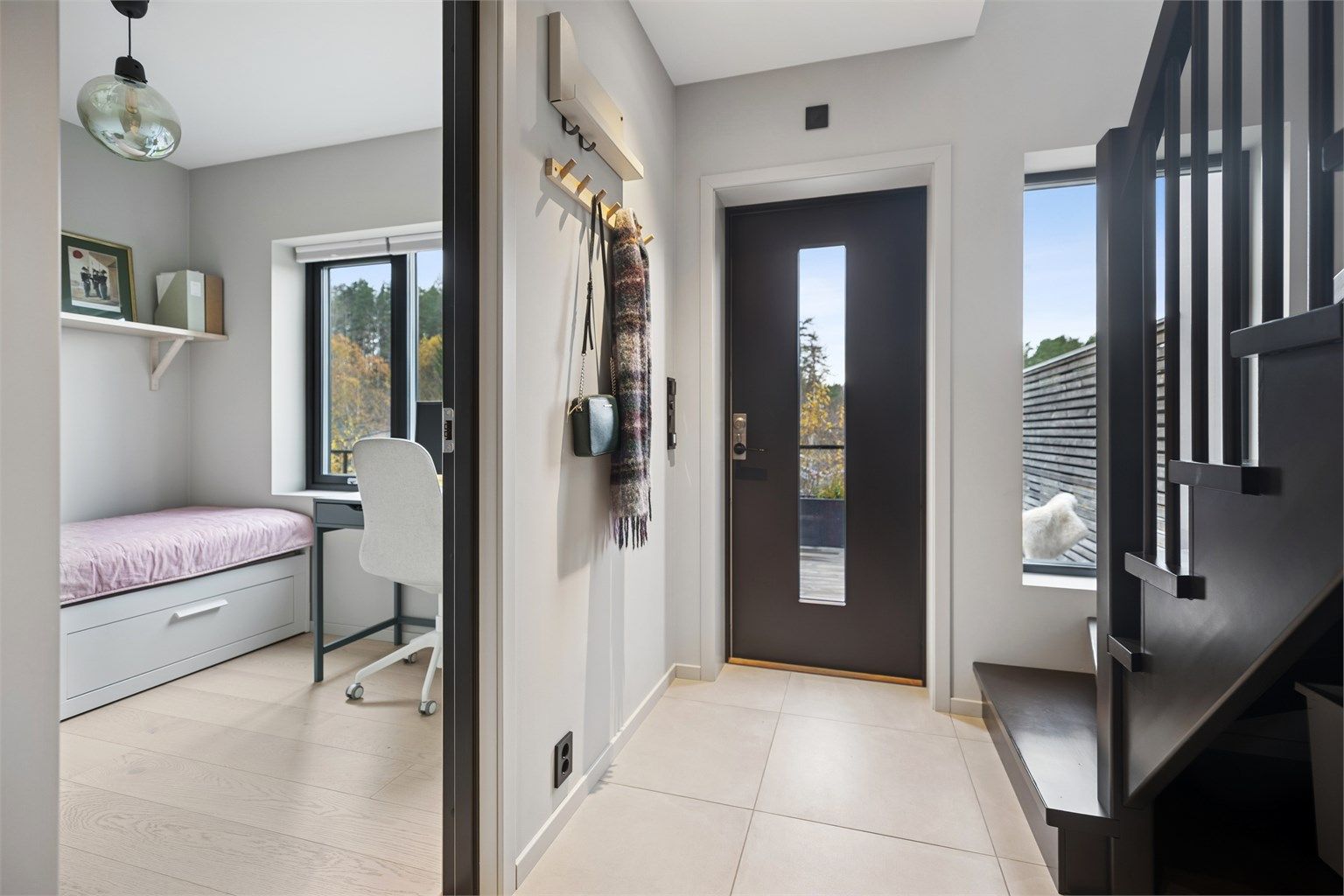 Velkommen inn – stor entré med flislagt gulv og gulvvarme, stort vindusfelt i inngangsdøren og vindu i trappen gir flott naturlig lys til rommet. 