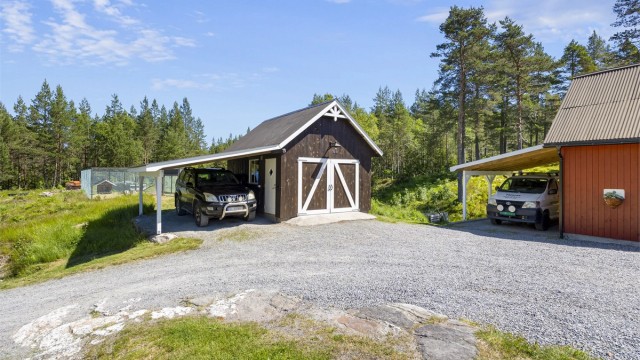 Til garasjen hører en carport fra 2018. I tillegg er det carport ved låven.