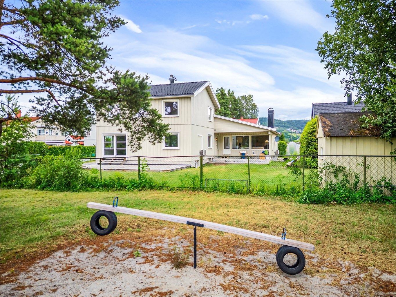 Delvis overbygd terrasse. Fin hage med utsikt mot friområde/lekeplass