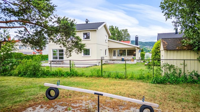 Delvis overbygd terrasse. Fin hage med utsikt mot friområde/lekeplass