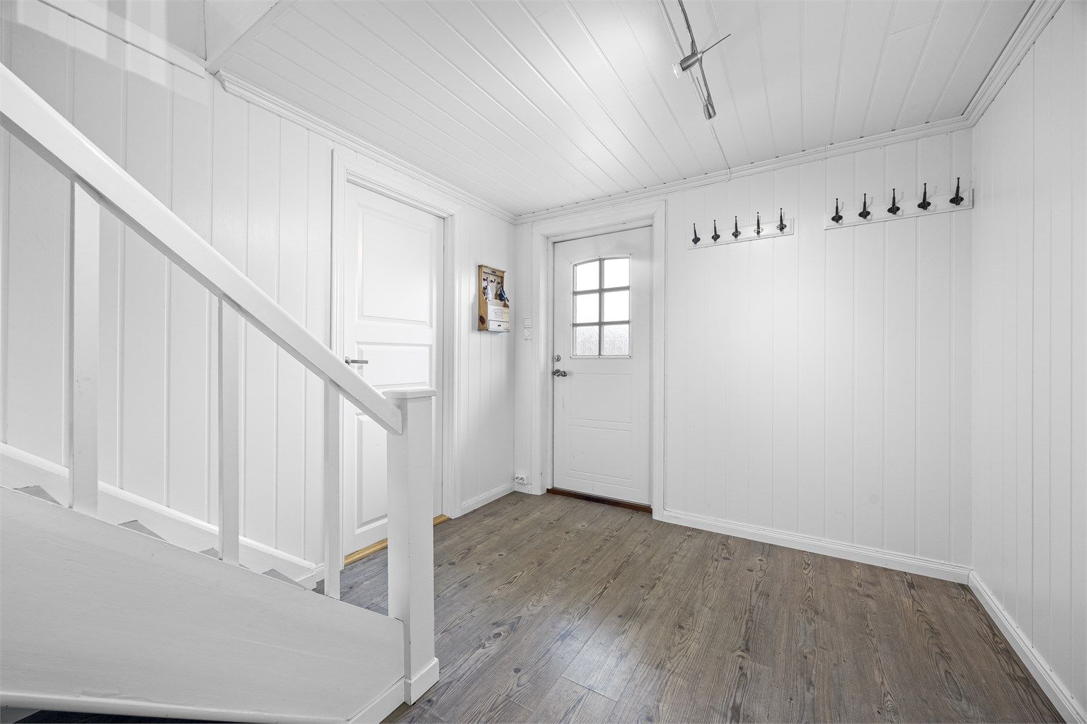 Lys og innbydende entré med plass til å henge fra seg yttertøy.