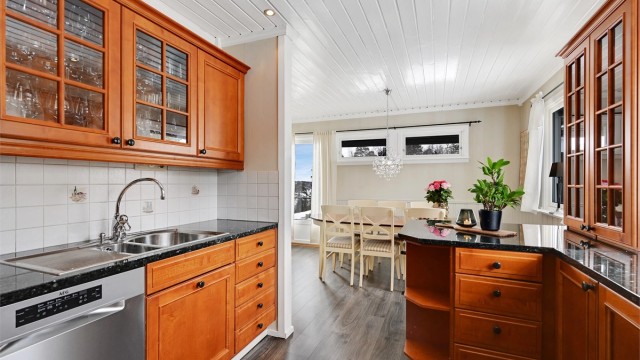 Kjøkkenet er fra Huseby og har innredning med profilerte fronter. Benkeplaten er av stein.