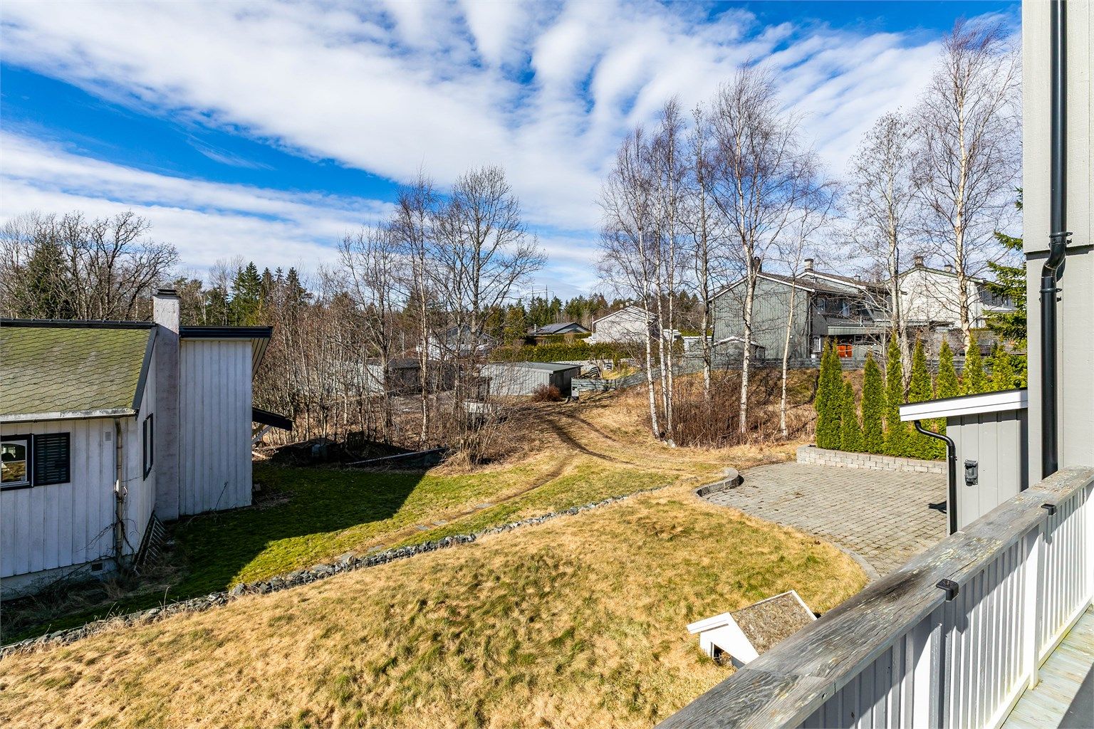 Utsyn over hagen fra terrassen. Adkomst skjer i dag over grøntareal. Eiendommen har tinglyst bruksrett til parkeringsplass i felles garasjerekke nedenfor.