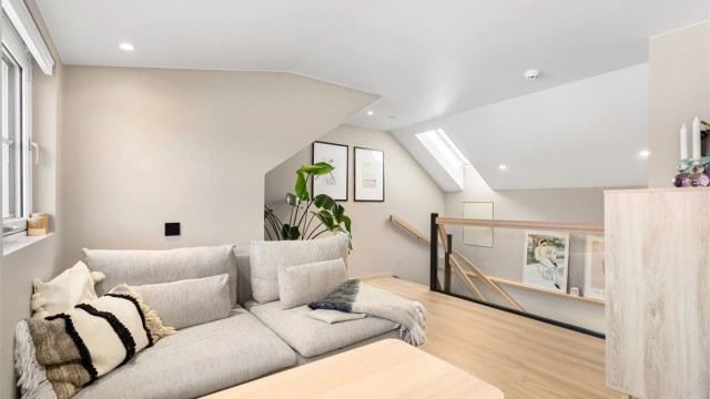 Loftsstue med plass til sofagruppe og tv-seksjon. Under vinduet til høyre i bildet er det også et kneloft med ekstra oppbevaringsplass.