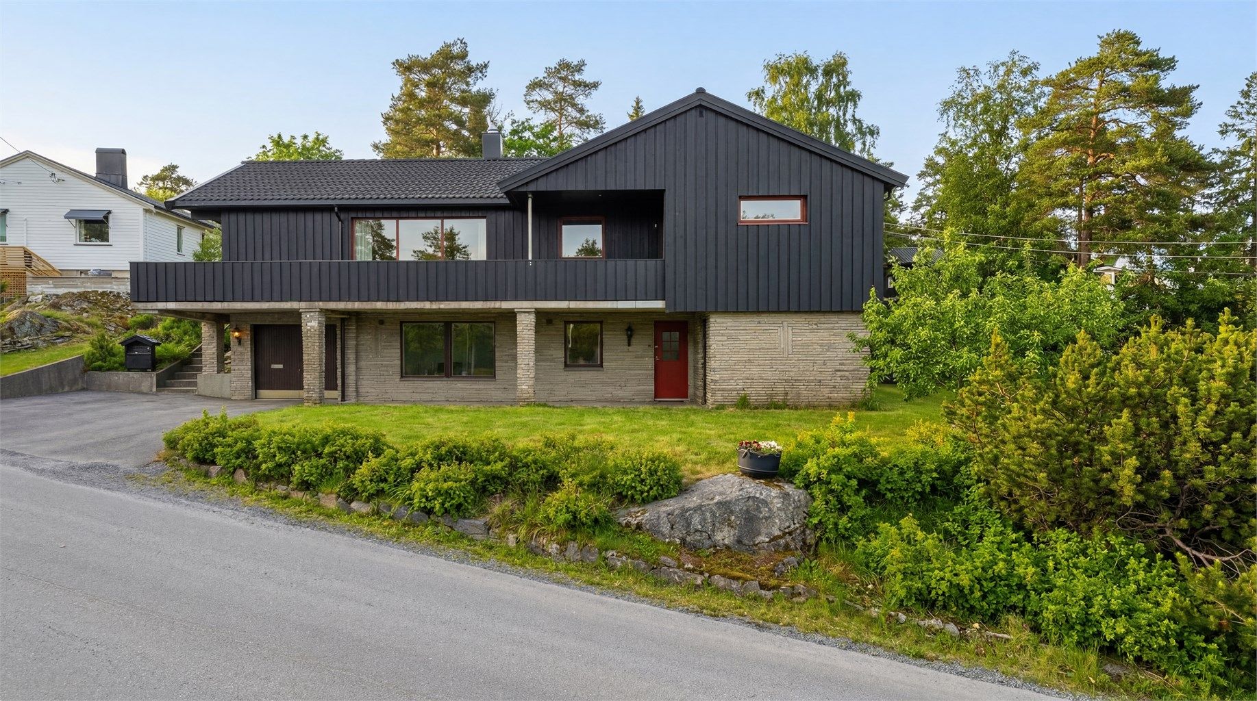 Sommerstid er eiendommen omkranset av grønn og frodig vegetasjon. Bildet er digitalt redigert for å vise mulighetene sommerstid. 