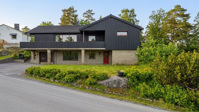 Sommerstid er eiendommen omkranset av grønn og frodig vegetasjon. Bildet er digitalt redigert for å vise mulighetene sommerstid.