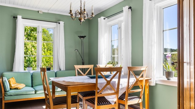Stuen har panel i taket og vinduer som slipper inn rikelig med dagslys.