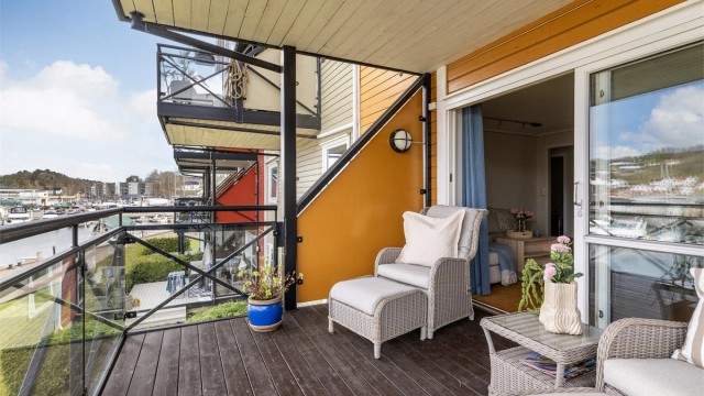 Balkongen er overbygget og har terrassebord på gulvet, samt utelys og stikkontakt.