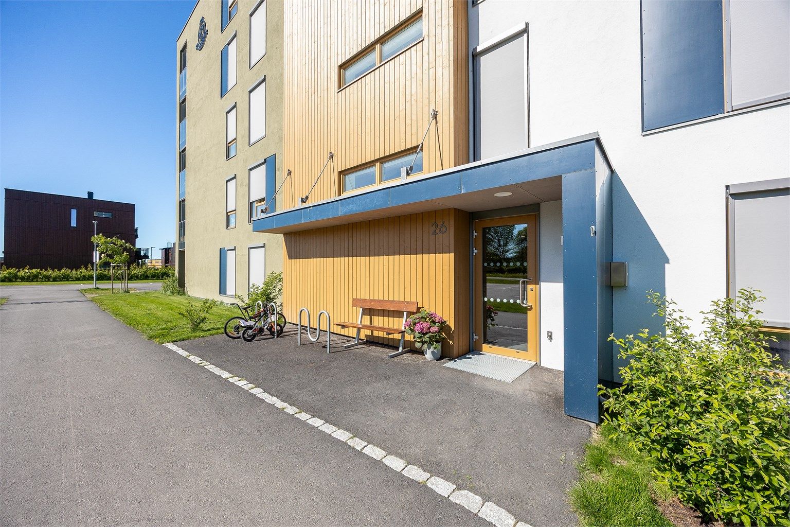 Yttervegger i stål-, betong- og trekonstruksjon med pussede overflater og trepanel.