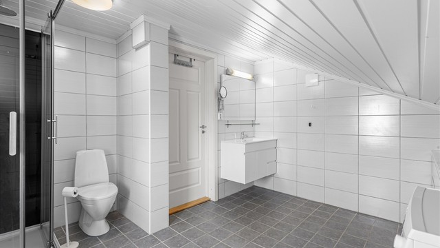Utleiedel i 2. etasje: Flislagt bad med gulvvarme. Innredet med vegghengt servantinnredning og ovenpåliggende servant. Dusjkabinett og gulvstående toalett. Opplegg for vaskemaskin.