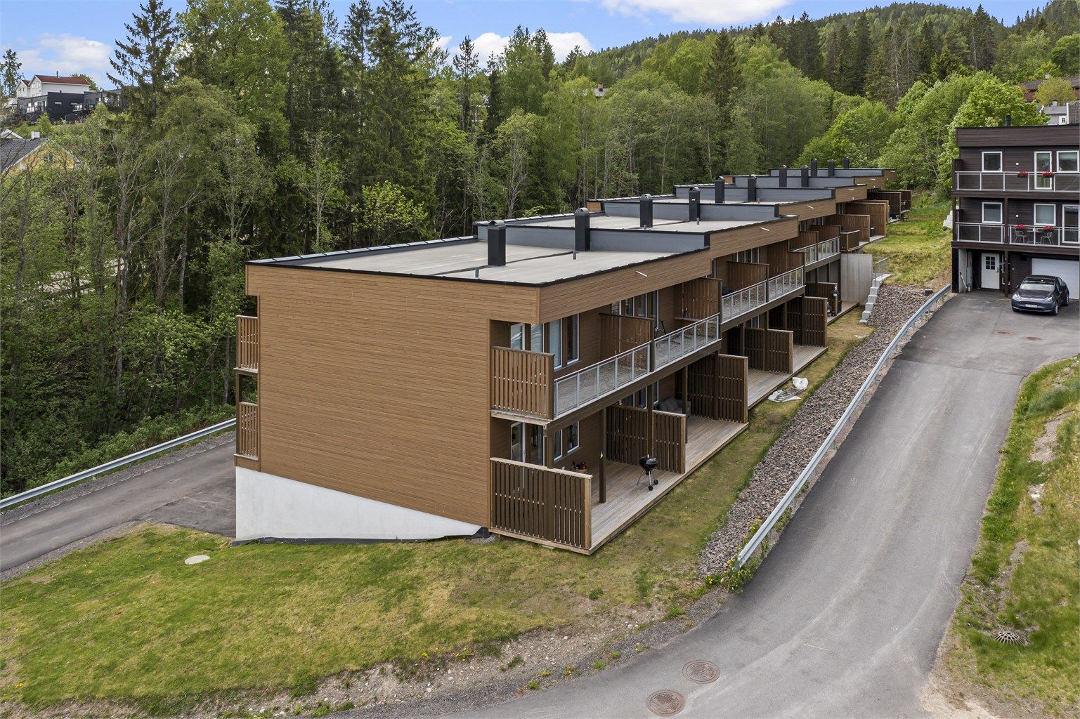 Stor terrasse på mark med en liten hage flekk uten for. Gresset blir fellesareal. 