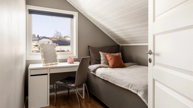 Et av soverommene i andre etasje, med plass til seng og skrivepult.