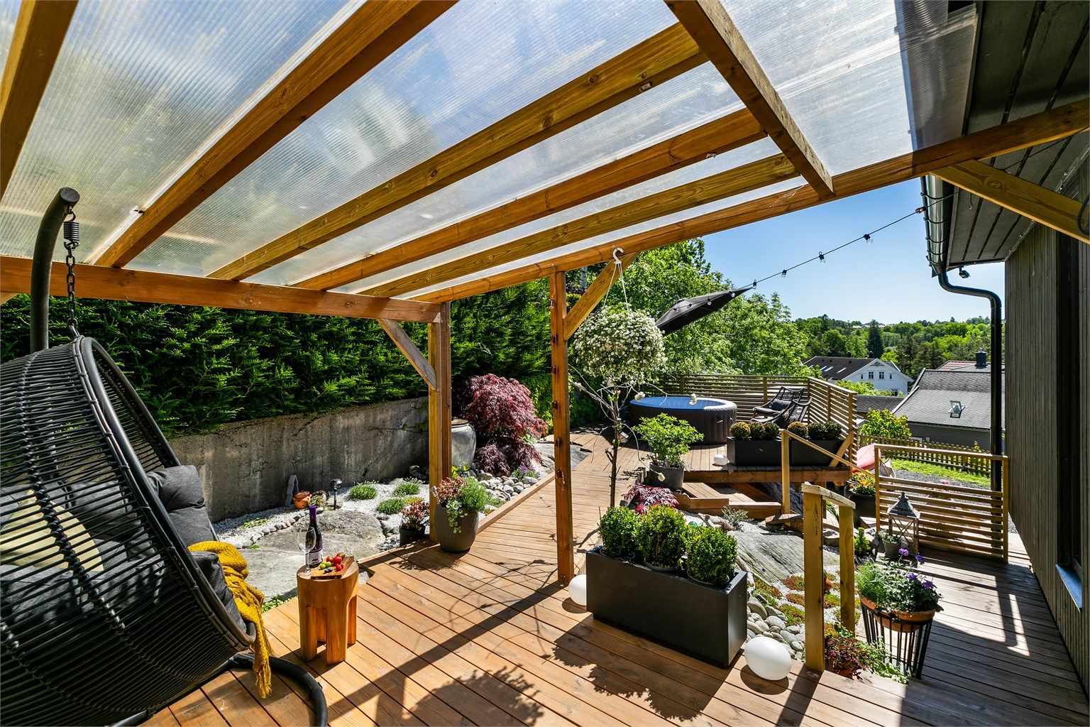 Pergola med tett tak gjør det mulig å sitte ute selv om sommerværet ikke er på sitt aller beste.