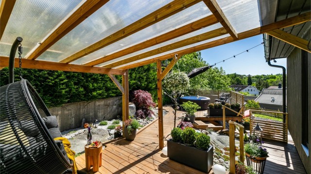 Pergola med tett tak gjør det mulig å sitte ute selv om sommerværet ikke er på sitt aller beste.