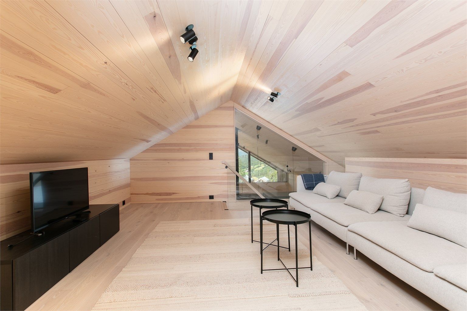 Trapperommet opp til loftstuen har en elegant glassvegg som bevarer åpenheten.