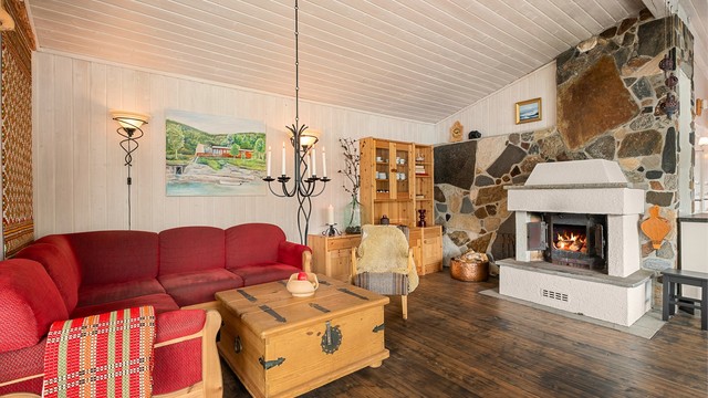 Hyggelig stue med peis som bidrar til en lun hytteatmosfære. Hytta har både peis og elektrisk oppvarming.