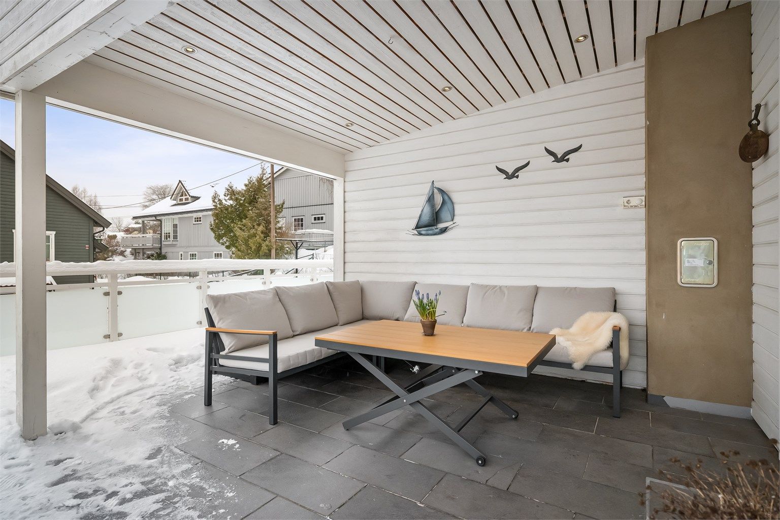 Terrassen er belagt med en kombinasjon av terrassebord og fliser.