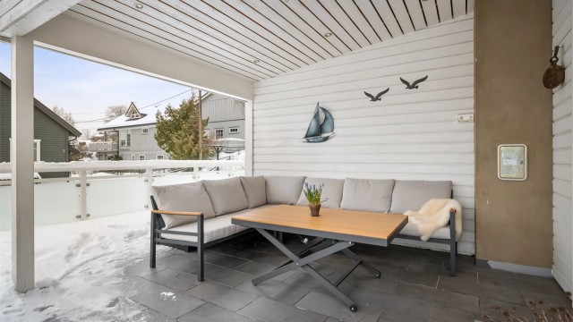 Terrassen er belagt med en kombinasjon av terrassebord og fliser.