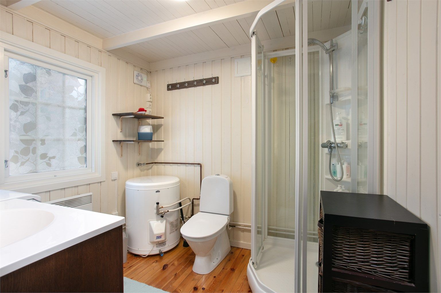 Badet er innredet med dusjkabinett, toalett og panelovn.