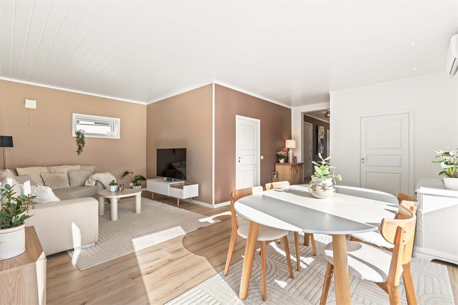 Stuen er malt i moderne farger og har god plass til både sofagruppe og spisebord.